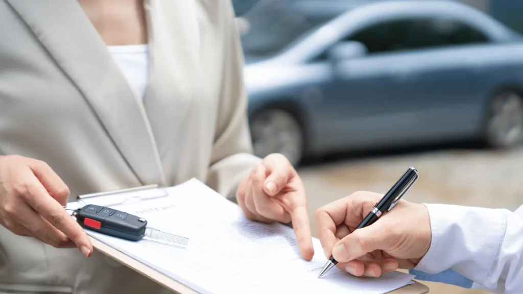 Car keys and a contract, representing checking a used car's history before buying